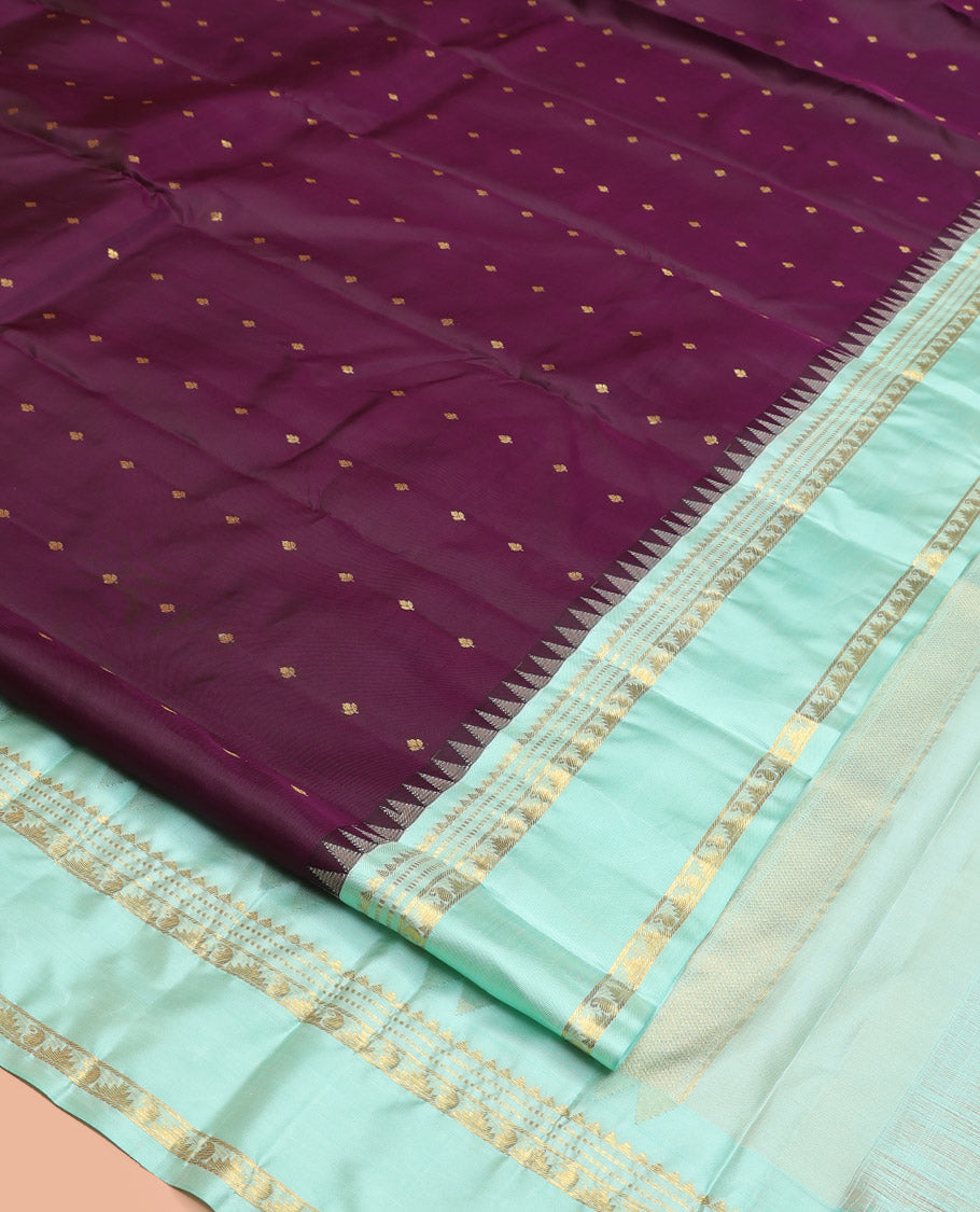 Purple Vasundhara Silk Saree, Spotlighted With Zari Buttas All Across Its Body, Complemented by Captivating Contrast Rettai Pettu Border of Thazampoo Rekku, Muthu, And Manga Designs, a Gleaming Zari Design Pallu, And Paired With a Contrast Blouse
