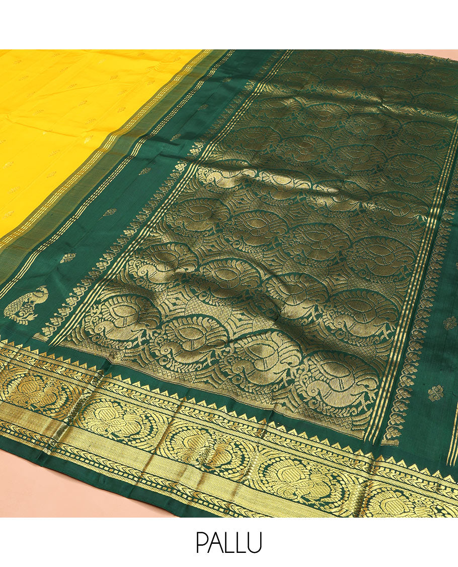 Yellow Kanchipuram Silk Saree, Decked Up with Zari Buttas, Complemented by Contrast One-Sided Korvai Border of Rekku, Banaras, Muthu, and Mayil Designs, Pallu Steeped with Round Mayil Designs, and Comes Without a Blouse