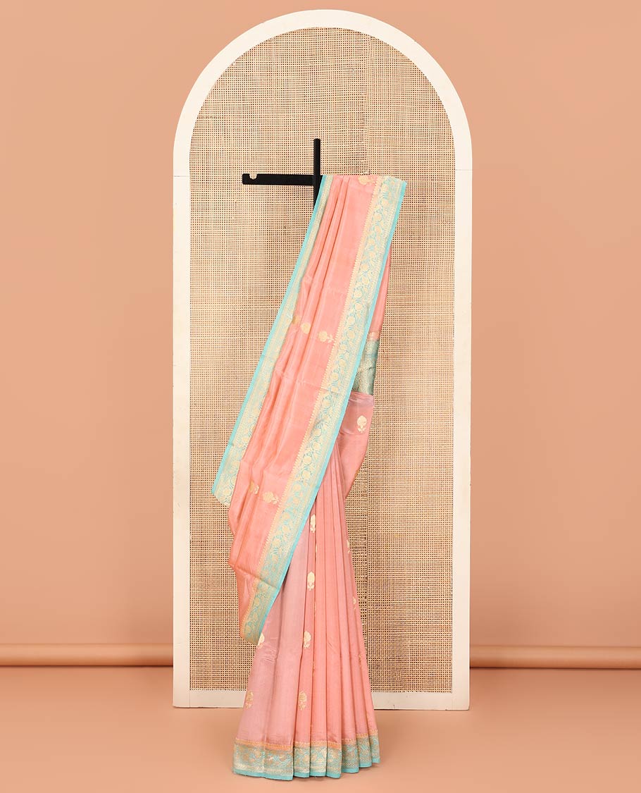 Peach Raw Mango Silk Saree Bedecked with Buttas, Features a Contrast floral creeper design Border, adorned with intricately designed Pallu, and comes with a Contrast Blouse