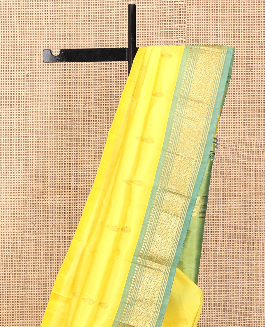 Yellow Kanchipuram Silk Saree, Sparsely Sparkled with Zari Buttas, a Contrast One-Sided Border of Panner Sombu, Banaras, Muthu, and Jaal Designs, a Zari Design Pallu, and No Blouse