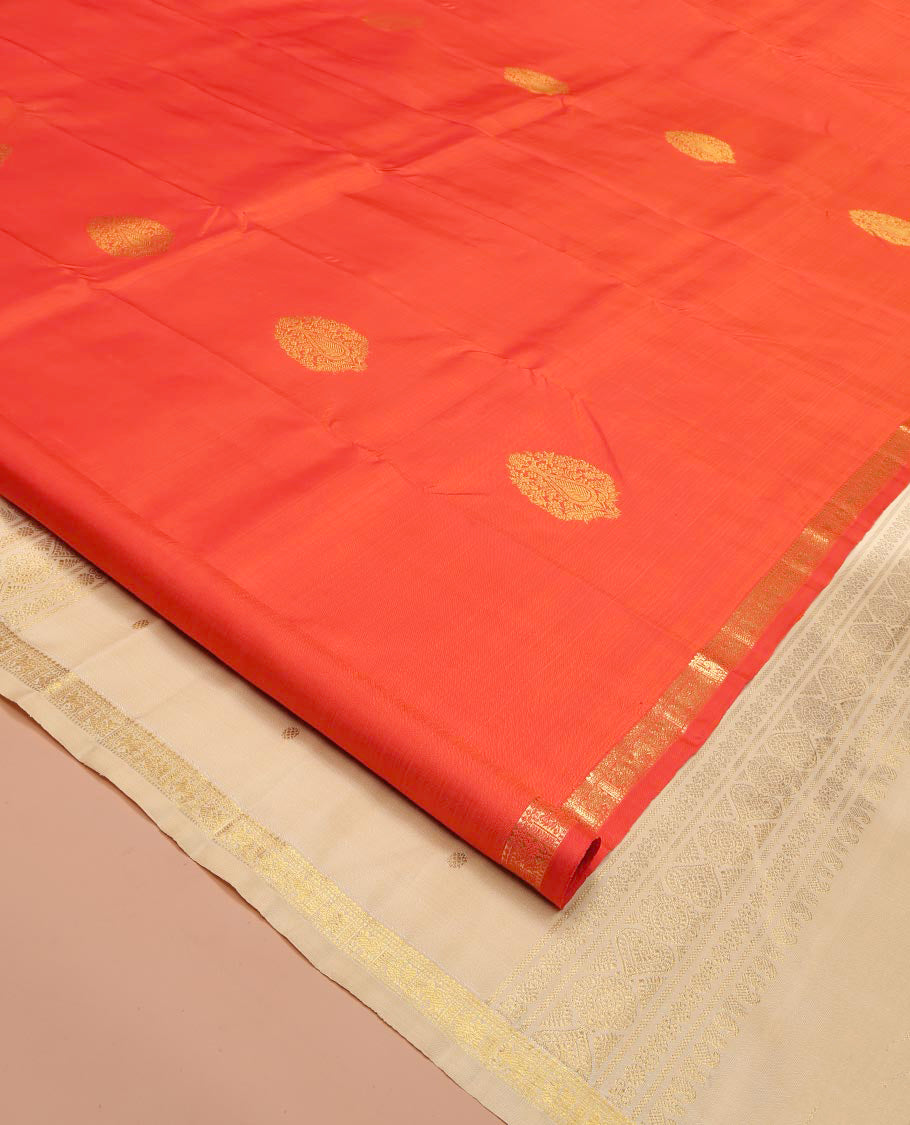 Orange Kanchipuram Silk Saree, Beautified with Zari Buttas All Over Its Body, Subtle Zari Piping Border, Complemented by a Contrast Pallu of Traditional Zari Designs, and Paired with a Contrast Blouse