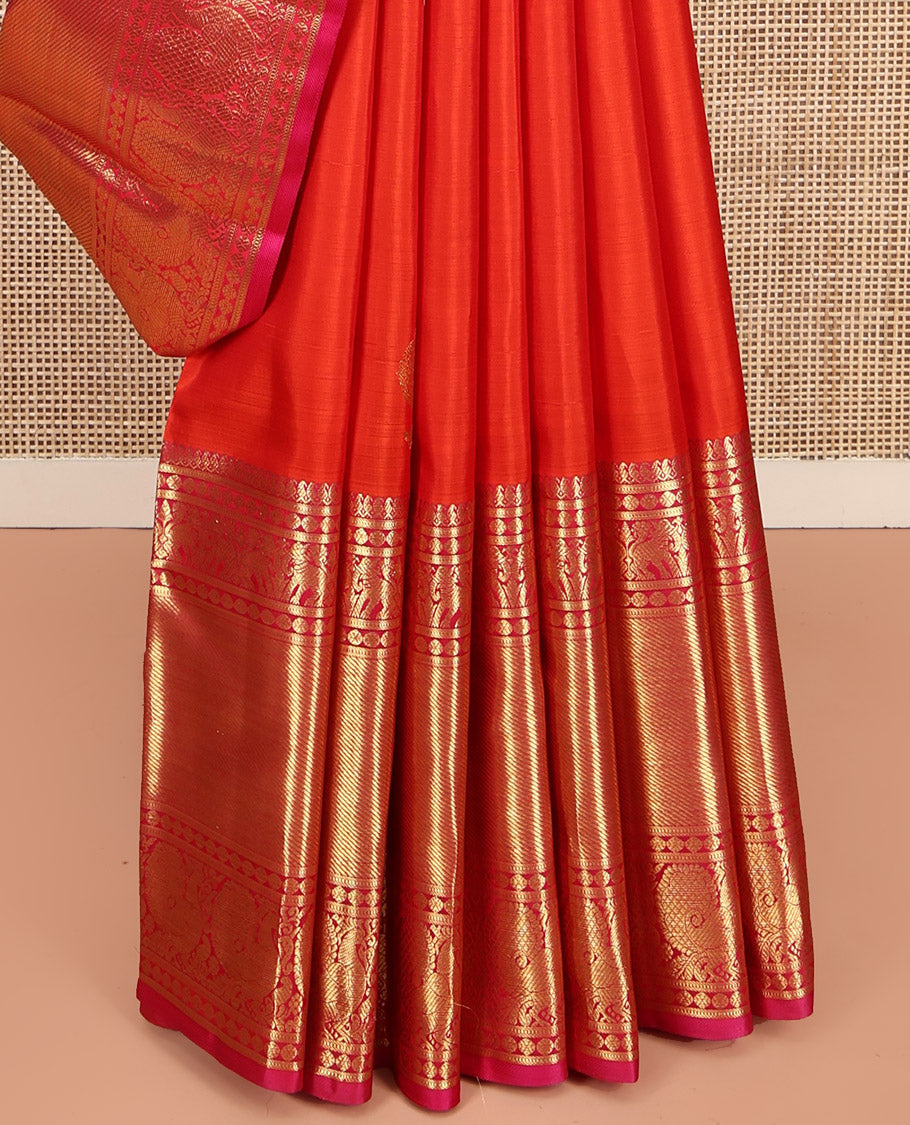 Orange Kanchipuram Silk Saree, Bedecked with Zari Buttas All Over Its Body, Complemented by a Contrast Border of Manga Mokku, Poun, Yaanai, and Mayil Designs, Grand Pallu of Kodi Visiry Designs, and Paired with a Contrast Blouse