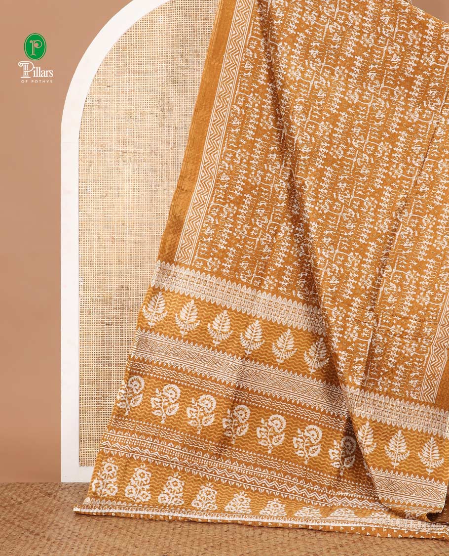 Mustard batik-style warli printed Litch crushed saree, batik chevron border, floral-geometric printed pallu & triangle motif blouse
