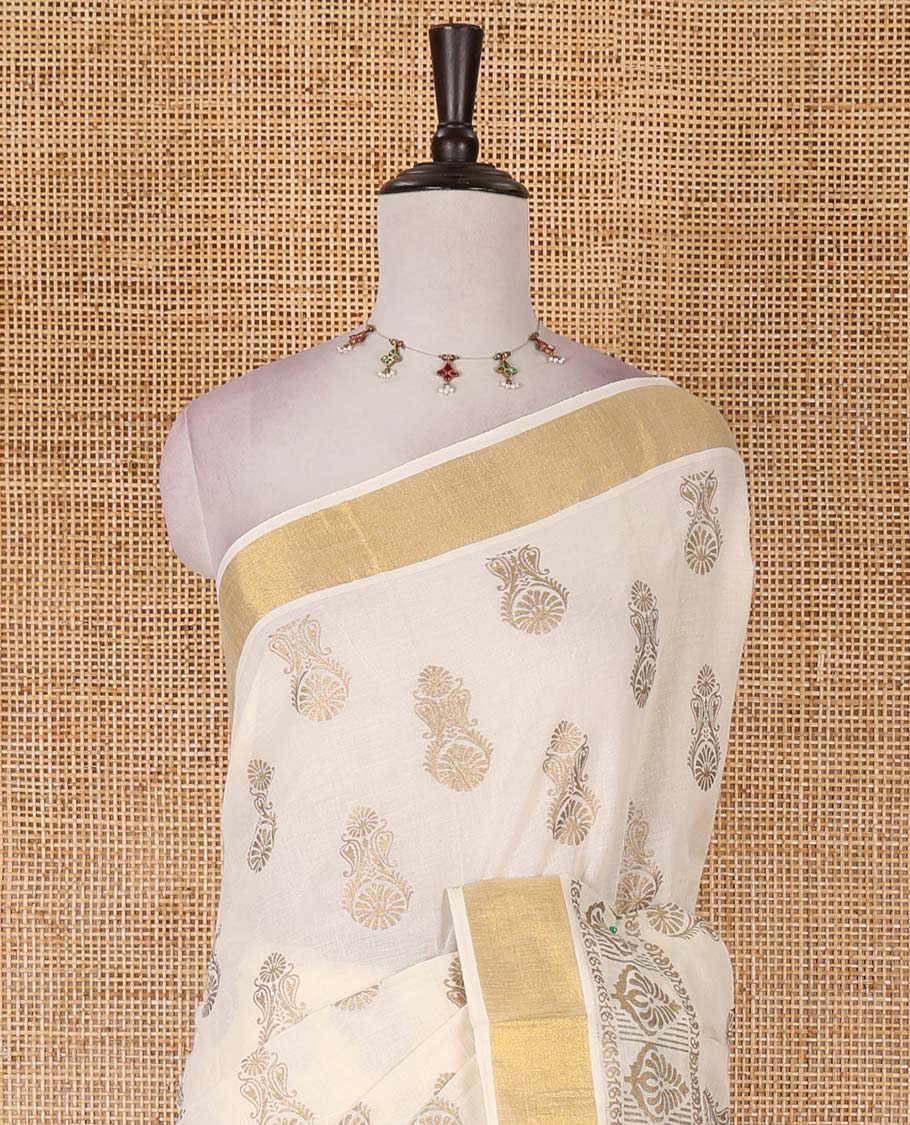 Cream Mughal-style buttas, golden foil printed Kerala cotton saree, zari border, pallu of paisley motifs, and a matching blouse