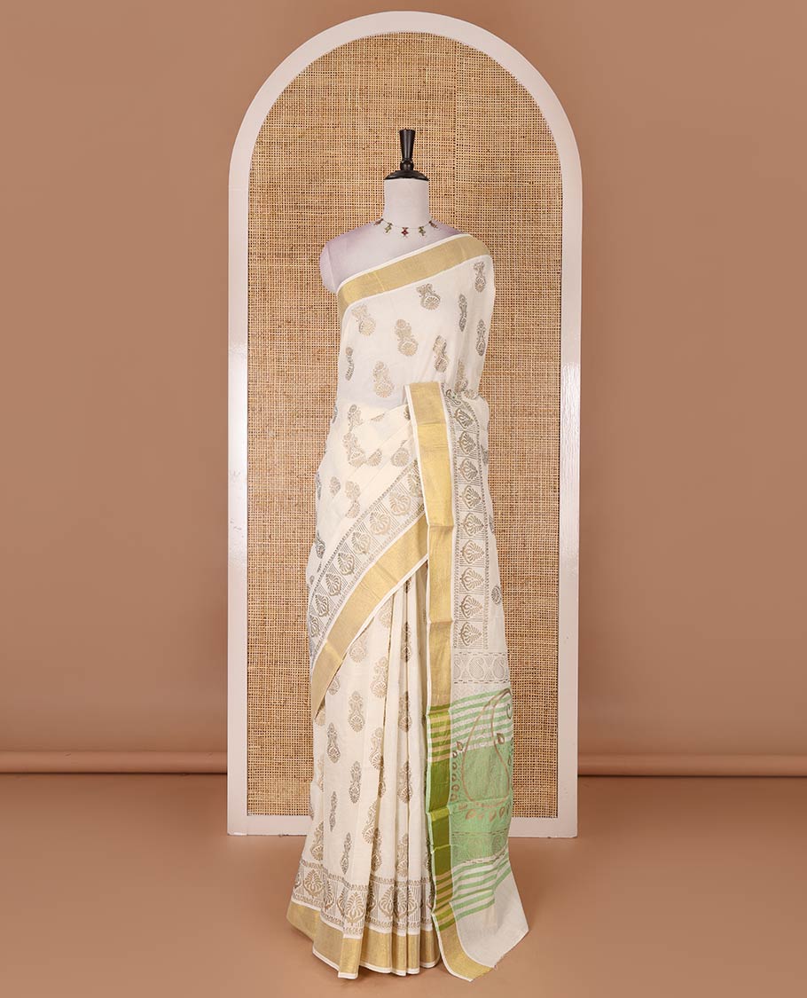 Cream Mughal-style buttas, golden foil printed Kerala cotton saree, zari border, pallu of paisley motifs, and a matching blouse