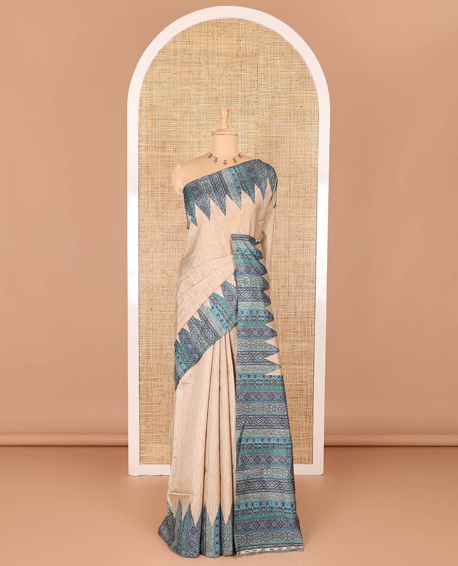 Chikku and blue plain Khicha Tussar saree, temple border of intricate Ajrakh print, Ajrakh printed pallu, and contrast Ajrakh printed blouse