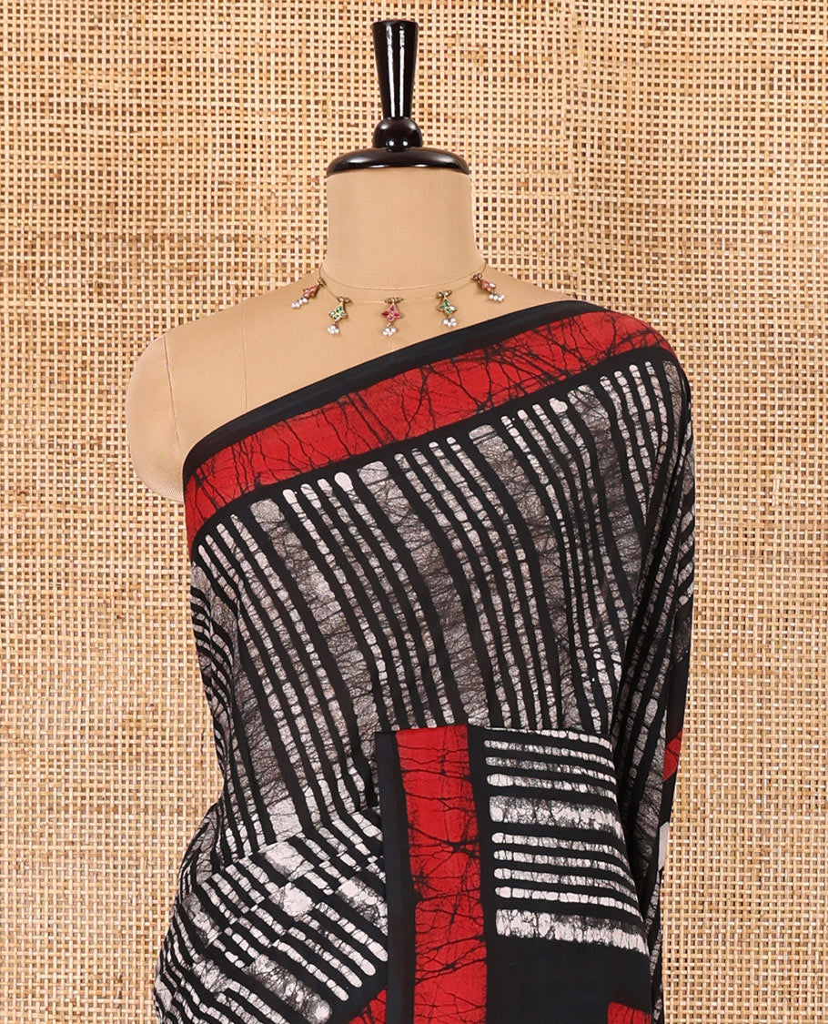 Black vertical stripes printed mul cotton saree, contrast batik printed border, pallu of geometric batik print, and a contrast printed blouse