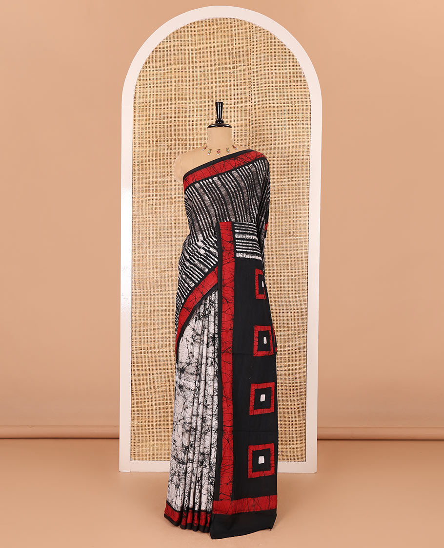 Black vertical stripes printed mul cotton saree, contrast batik printed border, pallu of geometric batik print, and a contrast printed blouse