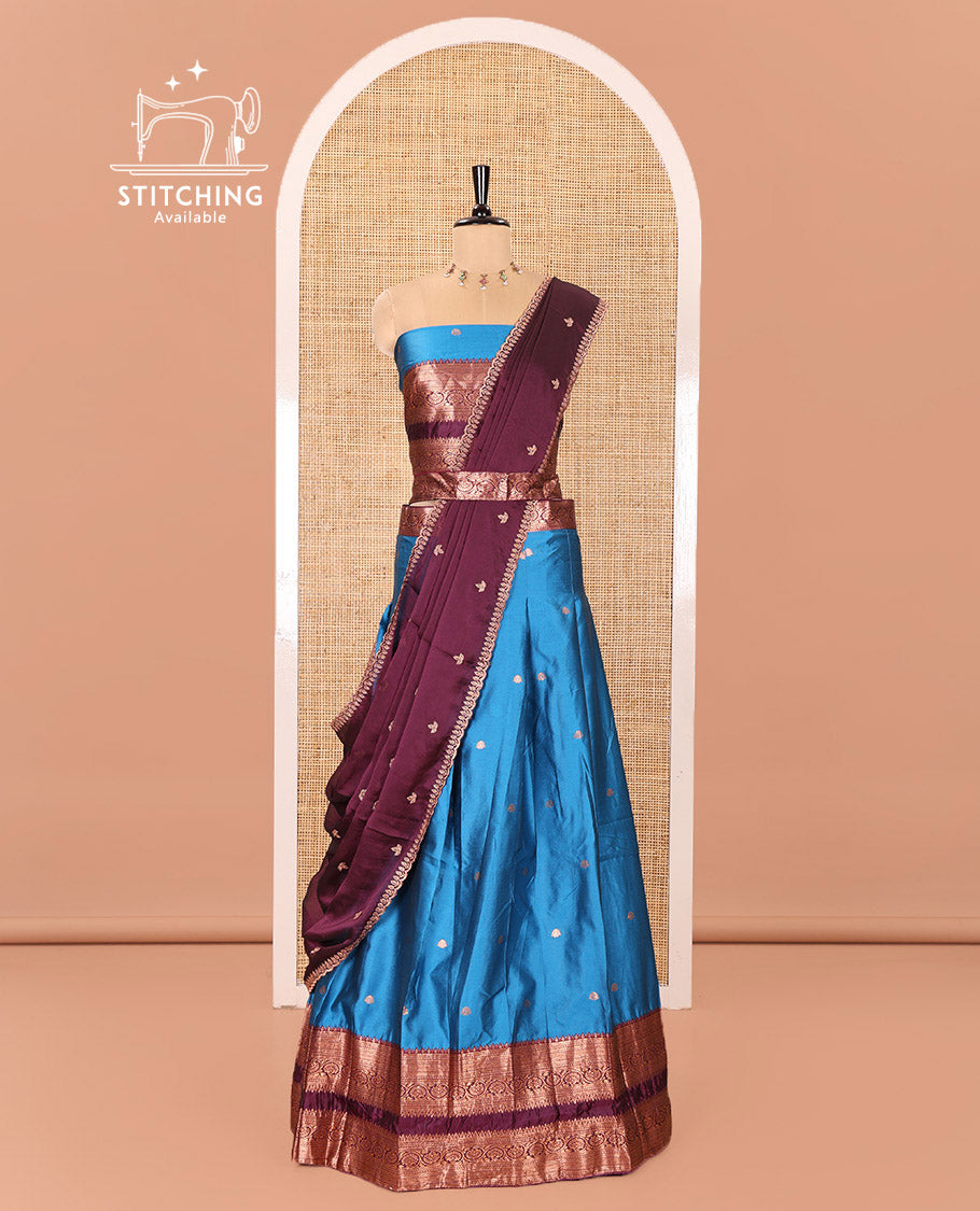 Blue and Purple Semi-Banarasi Half-Saree Featuring Zari Buttas Skirt, Complemented by Contrast Rettai Pettu, Traditional Border of Floral Creeper Designs, Paired with a Matching Blouse, and a Satin Georgette Embroidered Scallop Dhavani