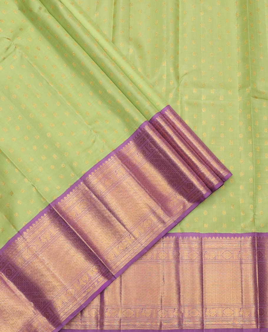 Green Pure Silk Half-Saree, Artfully Detailed with Mayil-Chakram Buttas on Its Skirt, Complemented by a Contrast Border of Rekku, Muthu, Diamond, Chakram, and Jaal Designs, Comes with a Contrast Blouse and a Dhavani of Jacquard Design