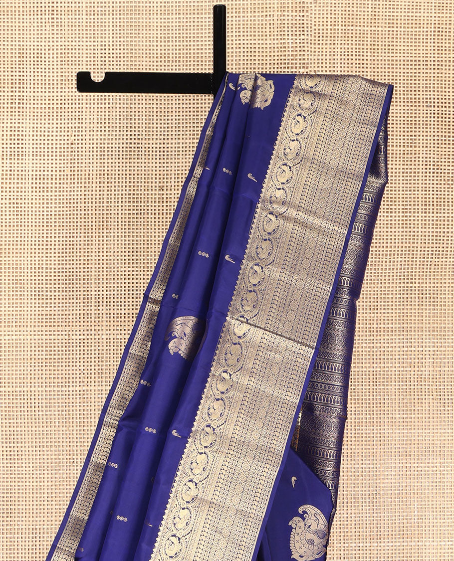 Blue Vasundhara Silk Saree, Decorated with Zari Buttas All Over Its Body, Highlighted by Zari Border of Rekku, Muthu, Mayil, Manga, Muthu, Kathir, Laddu Kamalam, and Cross Neli Designs, Pallu Mirrors the Same Designs, and Paired with a Matching Blouse