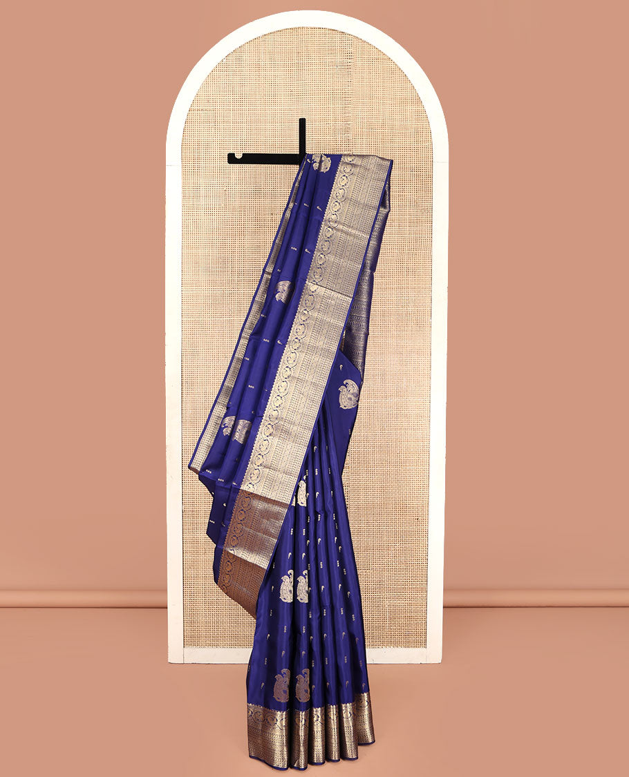Blue Vasundhara Silk Saree, Decorated with Zari Buttas All Over Its Body, Highlighted by Zari Border of Rekku, Muthu, Mayil, Manga, Muthu, Kathir, Laddu Kamalam, and Cross Neli Designs, Pallu Mirrors the Same Designs, and Paired with a Matching Blouse