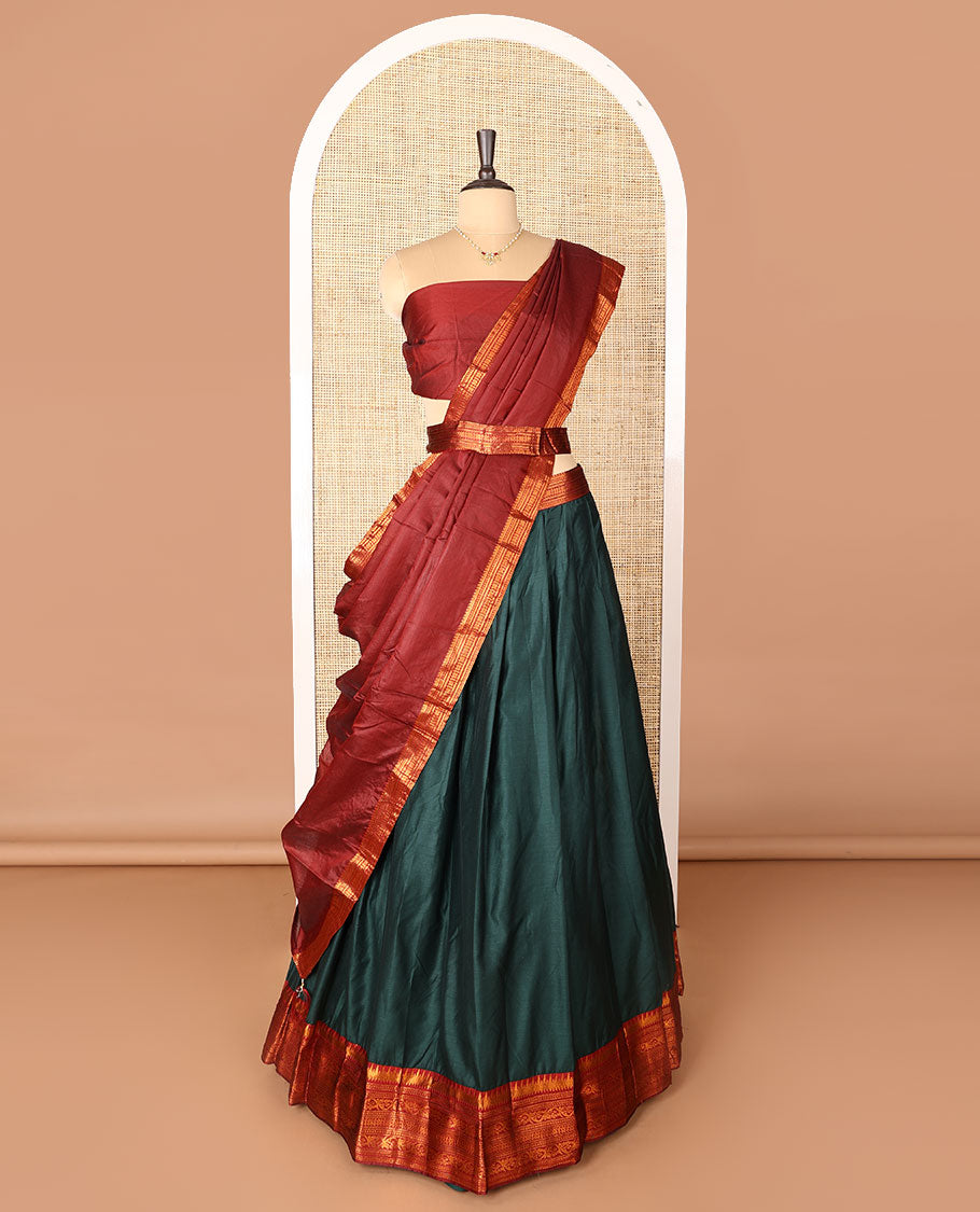 Dark green art-silk half-saree, plain with contrast temple traditional design bordered skirt, contrast blouse, and plain zari bordered dhavani