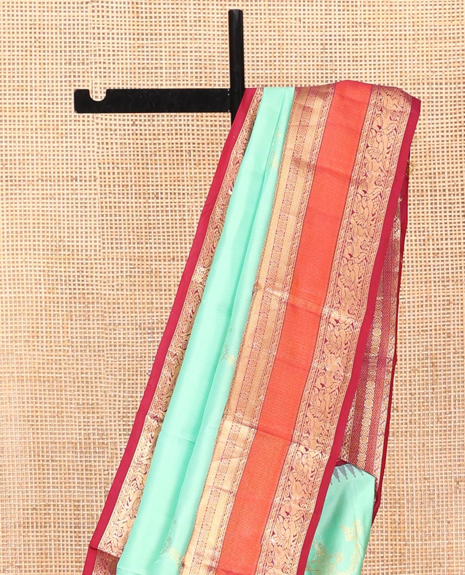 Turquoise Vasundhara Silk Saree, Meticulously Crafted with Zari Buttas on Its Body, Complemented by Contrast Border of Muthu, Mayil Kann, Chakram, Mayil, and Kuthirai Designs, an Intricately Designed Pallu, and Paired with a Contrast Blouse