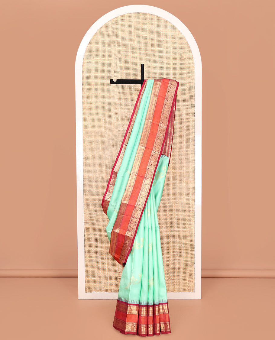 Turquoise Vasundhara Silk Saree, Meticulously Crafted with Zari Buttas on Its Body, Complemented by Contrast Border of Muthu, Mayil Kann, Chakram, Mayil, and Kuthirai Designs, an Intricately Designed Pallu, and Paired with a Contrast Blouse