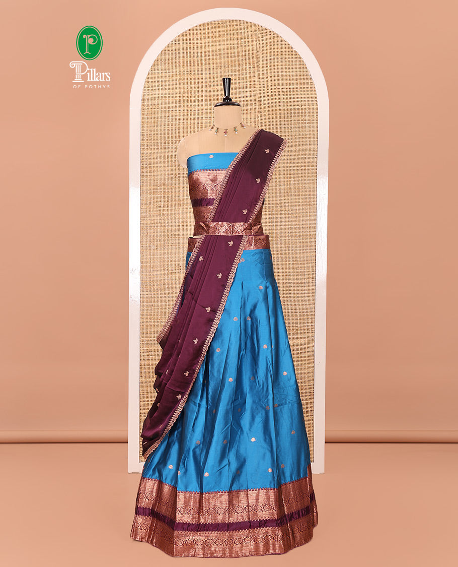 Blue and Purple Semi-Banarasi Half-Saree Featuring Zari Buttas Skirt, Complemented by Contrast Rettai Pettu, Traditional Border of Floral Creeper Designs, Paired with a Matching Blouse, and a Satin Georgette Embroidered Scallop Dhavani