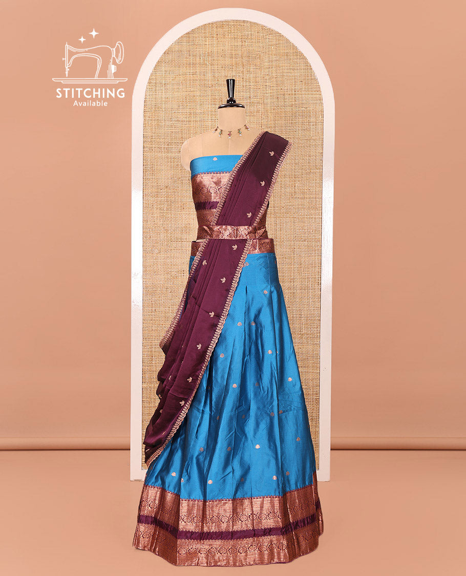Blue and Purple Semi-Banarasi Half-Saree Featuring Zari Buttas Skirt, Complemented by Contrast Rettai Pettu, Traditional Border of Floral Creeper Designs, Paired with a Matching Blouse, and a Satin Georgette Embroidered Scallop Dhavani