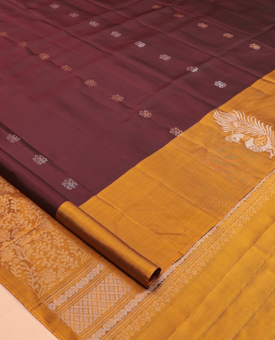 Maroon Mayuri Lite Silk Mix Saree, Bedecked with Zari Buttas, Complemented By Contrast Peacock Buttas Border, a Floral Vine Pallu, and a Contrast Blouse