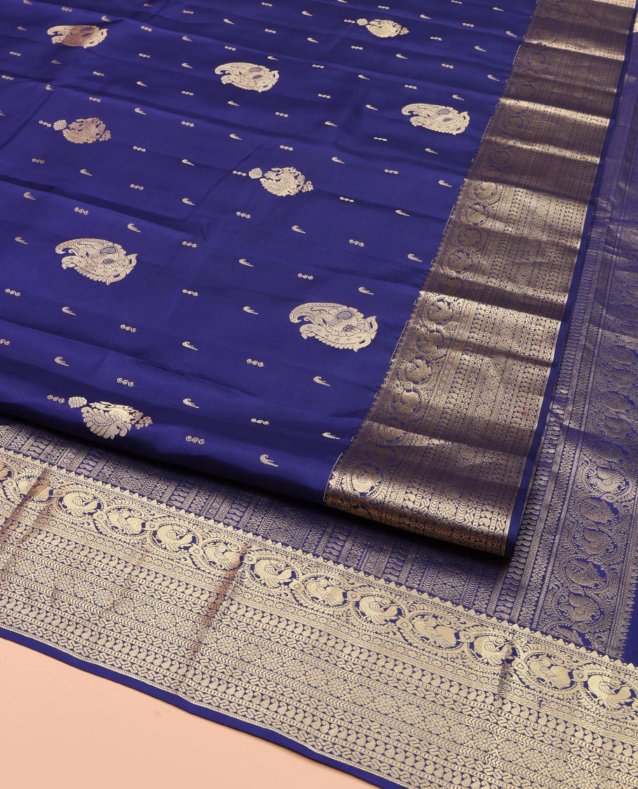 Blue Vasundhara Silk Saree, Decorated with Zari Buttas All Over Its Body, Highlighted by Zari Border of Rekku, Muthu, Mayil, Manga, Muthu, Kathir, Laddu Kamalam, and Cross Neli Designs, Pallu Mirrors the Same Designs, and Paired with a Matching Blouse
