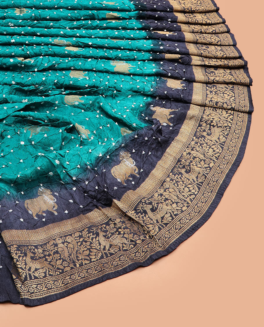 Blue bandhani dots and Pichwai cow motifs bandhani silk saree, contrast Pichwai cow and animal motifs zari border, and patola-style butta enclosed jaal pallu