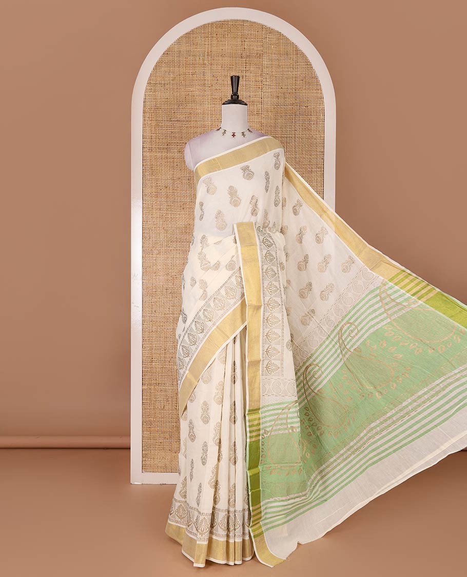 Cream Mughal-style buttas, golden foil printed Kerala cotton saree, zari border, pallu of paisley motifs, and a matching blouse