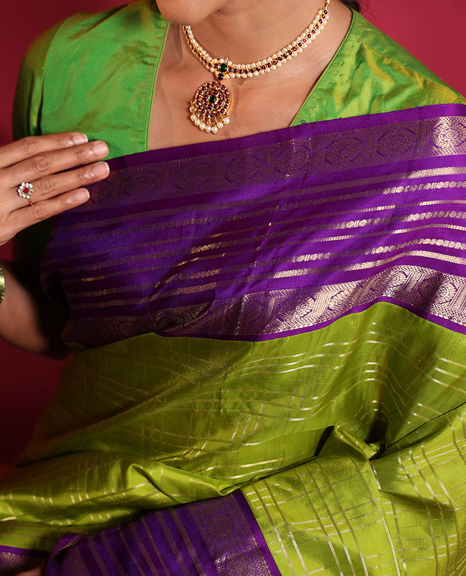 Green Vasundhara Silk Saree, Spotlighted with Zari Checked Design All Over Its Body, Complemented by a Contrast Varisai Pettu Border of Muthu, Poun, and Chakram Designs, Grandly Embellished Pallu of Jaal Designs, and Paired with a Contrast Blouse