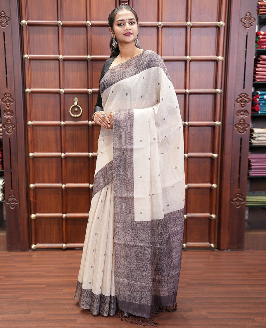 Chikku and Black Tissue Linen Saree, Delicately Printed with Floral Motifs on Its Body, Complemented by a Contrast Border of Paisley Designs, Pallu Steeped with Paisley Designs, and Paired with a Contrast Blouse