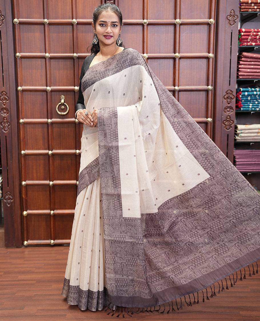 Chikku and Black Tissue Linen Saree, Delicately Printed with Floral Motifs on Its Body, Complemented by a Contrast Border of Paisley Designs, Pallu Steeped with Paisley Designs, and Paired with a Contrast Blouse