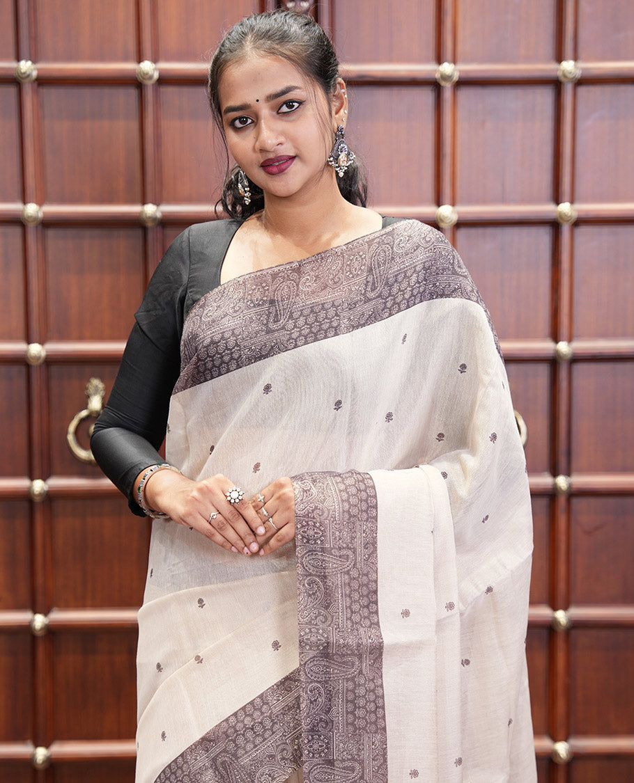 Chikku and Black Tissue Linen Saree, Delicately Printed with Floral Motifs on Its Body, Complemented by a Contrast Border of Paisley Designs, Pallu Steeped with Paisley Designs, and Paired with a Contrast Blouse