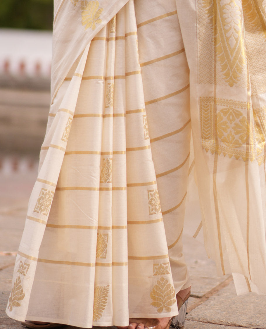 Cream Kerala Cotton Saree, Delicately Woven with Zari Stripes and Buttas, Highlighted by an Intricate Pallu and a Matching Blouse
