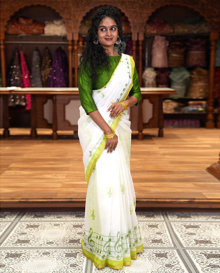 White and green musical note motifs printed Chanderi cotton saree, zari piping border, geometric printed pallu, and a unique motifs printed blouse