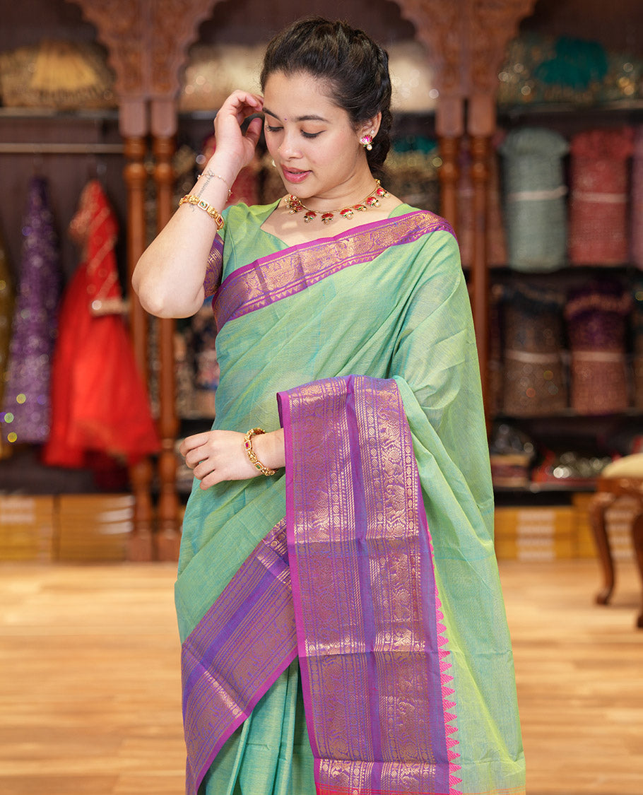Pista Green Plain Chettinad Cotton Saree Decked Up with a Contrasting Temple Rettai Pettu Border of Peacock-Elephant Motifs, a Subtle Pallu of Stripes, and a Matching Blouse