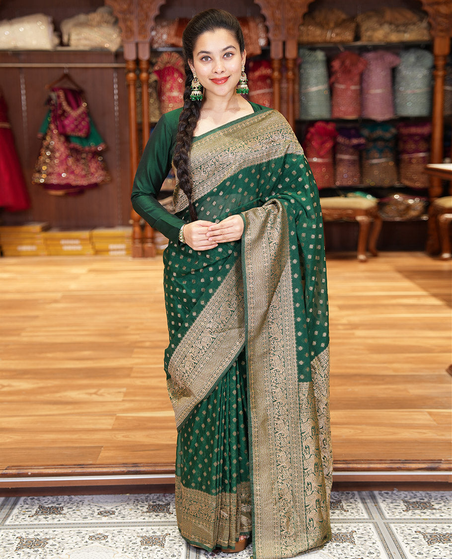 Green Semi-Banaras Khaddi Georgette, Finely Detailed with Zari Buttas All Over Its Body, Subtly Sparkled Traditional Border of Rudraksham, Elephant, and Floral Vine Designs, Pallu of a Herd of Elephants, and Paired with a Matching Blouse