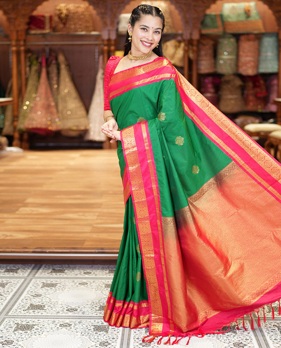 Green Kanchipuram Budget Silk Saree, Detailed with Zari Buttas All Over Its Body, Complemented by a Contrast Traditional Zari Rettai Pettu Border of Chakram Designs, Gracefully Embellished Pallu, and Paired with a Contrast Blouse