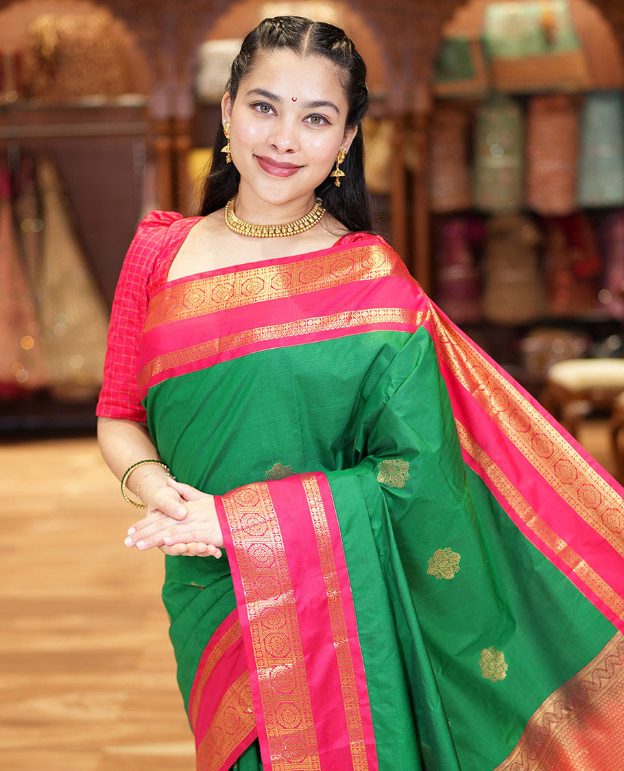 Green Kanchipuram Budget Silk Saree, Detailed with Zari Buttas All Over Its Body, Complemented by a Contrast Traditional Zari Rettai Pettu Border of Chakram Designs, Gracefully Embellished Pallu, and Paired with a Contrast Blouse
