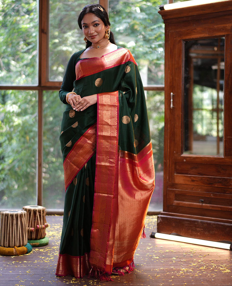 Green Vasundhara Silk Saree, Elevated with Mayil Zari Buttas All Over Its Body, Complemented by a Contrast Border of Thilakam Mokku, Kathir, and Round Mayil Designs, Grand Jaal Pallu, and Paired with a Contrast Blouse