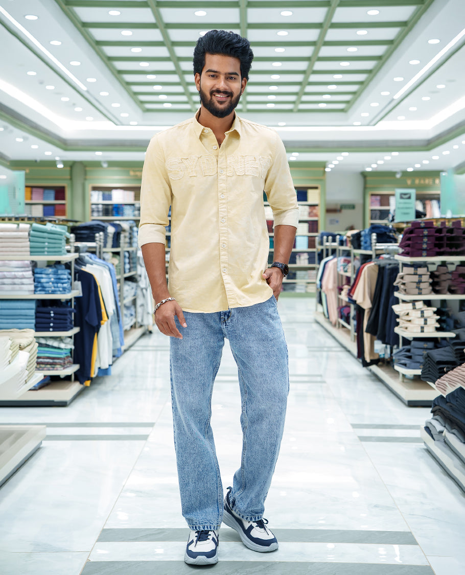 Cream Cotton Blended Casual Shirt, Bedecked with Acid-Washed and Typography Patch Embroidery on the Chest, Featuring a Spread Collar, Full Sleeves, Slim Fit, and Regular Length