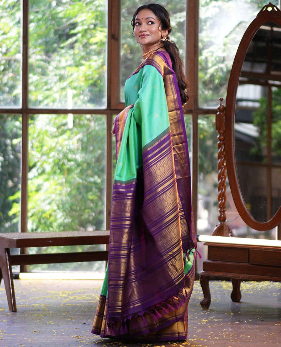 Rexona Green Vasundhara Silk Saree, Beautified with Sparse Stripes and Zari Buttas, Complemented by a Contrast Border of Thilakam, Banaras, Muthu, and Round Mayil Designs, Pallu Steeped with Traditional Designs, and Paired with a Contrast Blouse