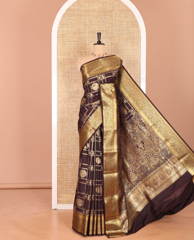 Brown Kanchipuram budget silk saree artfully woven with chakram zari butta enclosed checks all over its body, complemented by zari traditional design border, Mughal-style intricately woven pallu, and paired with a Matching blouse