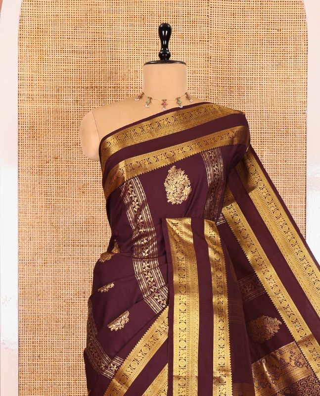 Brown Kanchipuram budget silk saree elevated with zari designs all over its body, complemented by rettai pettu traditional zari design border, Mughal-style intricately woven pallu, and paired with a Matching blouse