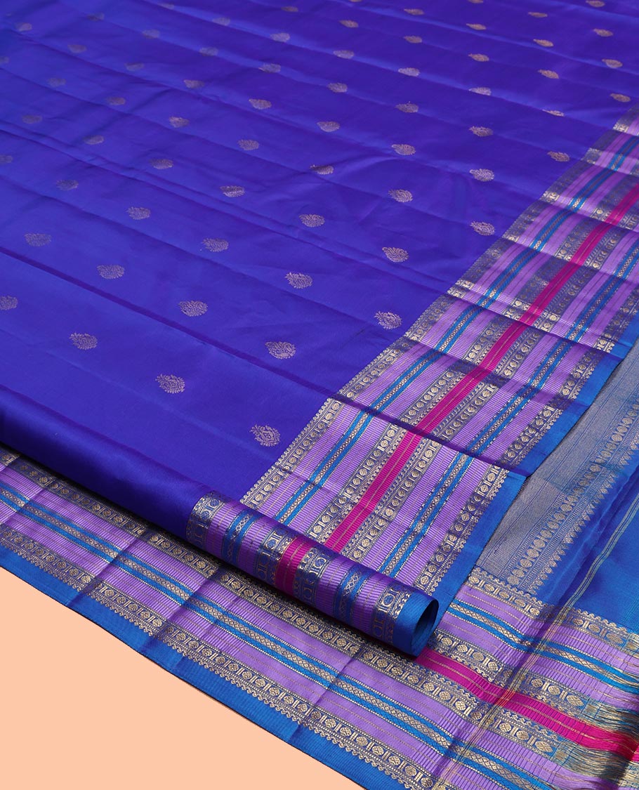 Violet and Mayil Blue Vasundhara Silk Saree, Subtly Sparkled with Zari Buttas All Over Its Body, Highlighted by Self-Border of Thilakam Mokku, Rudraksham, Muthu, and Mayil Kann Designs, Diagonally Striped Pallu, and Paired with a Matching Blouse