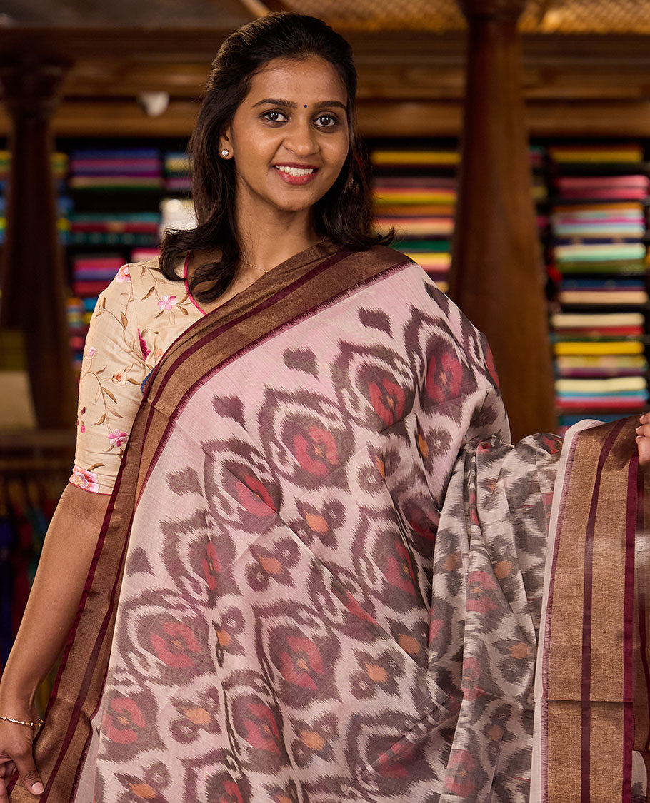 Pastel pink Pochampally Ikkat-style ogee patterned silk cotton saree, contrast zari border, and ikkat design pallu