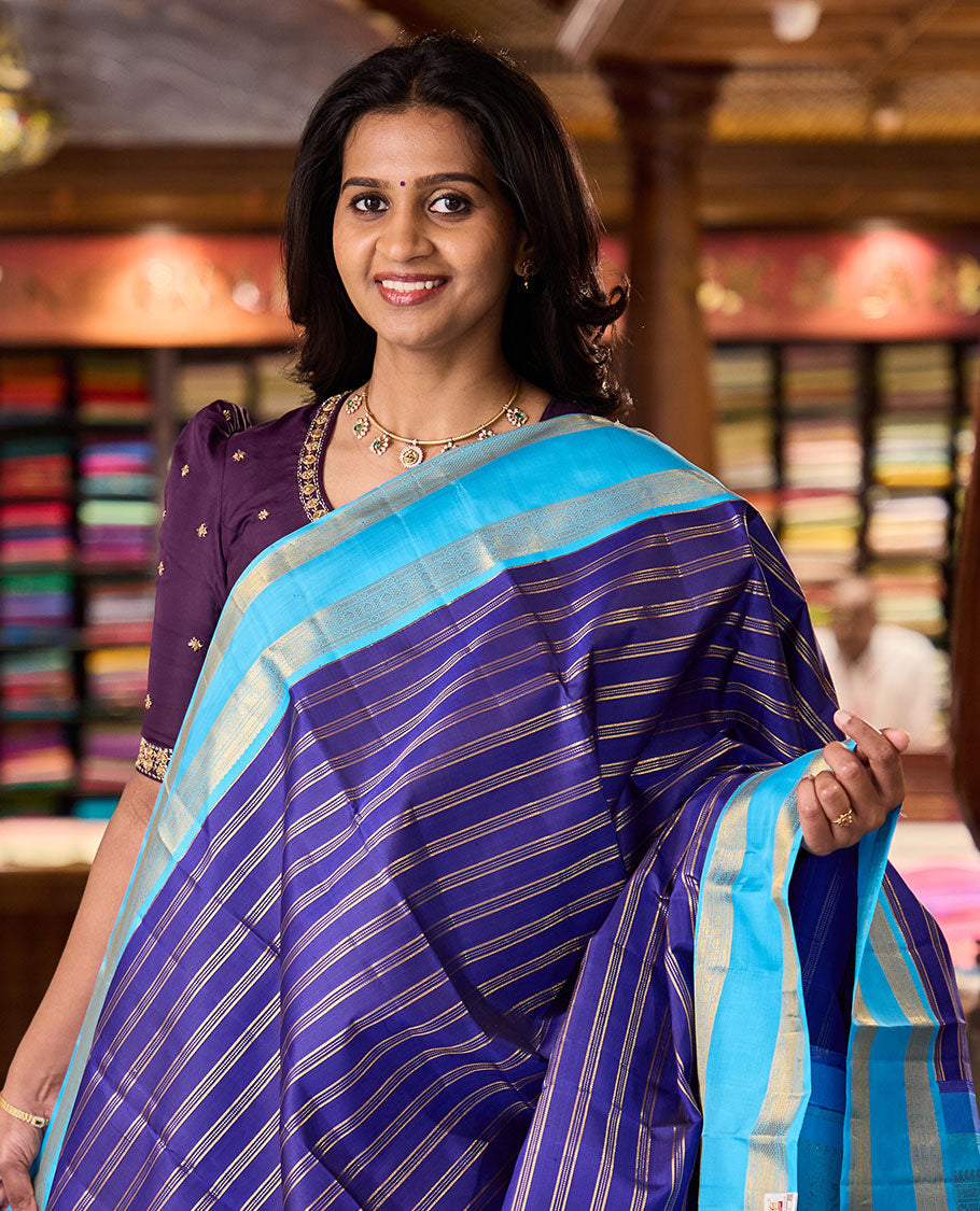 Blue zari striped Kanchipuram silksaree, contrast rettai pettu border of traditional zari designs, and zari-rich jaal pallu