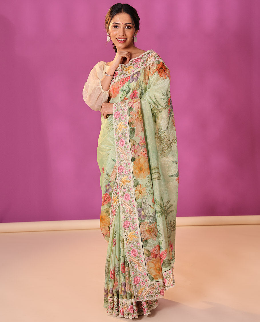 Green Dola Saree Gleamed Up with Gold Buttas and Colorful Tropical Floral Printed All Over Its Body, Complemented by a Contrast Scallop Floral Thread Embroidery Border, Pallu Depicts the Same Body Designs, and Paired with a Contrast Blouse