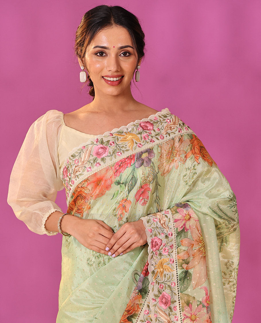 Green Dola Saree Gleamed Up with Gold Buttas and Colorful Tropical Floral Printed All Over Its Body, Complemented by a Contrast Scallop Floral Thread Embroidery Border, Pallu Depicts the Same Body Designs, and Paired with a Contrast Blouse