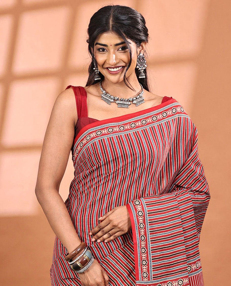 Red-base Saree, Subtly Sparkled with Vertical Stripes All Across Its Body, Highlighted by Floral Ajrakh-style Printed Border, Ajrakh Printed Pallu, and Paired with a Matching Blouse