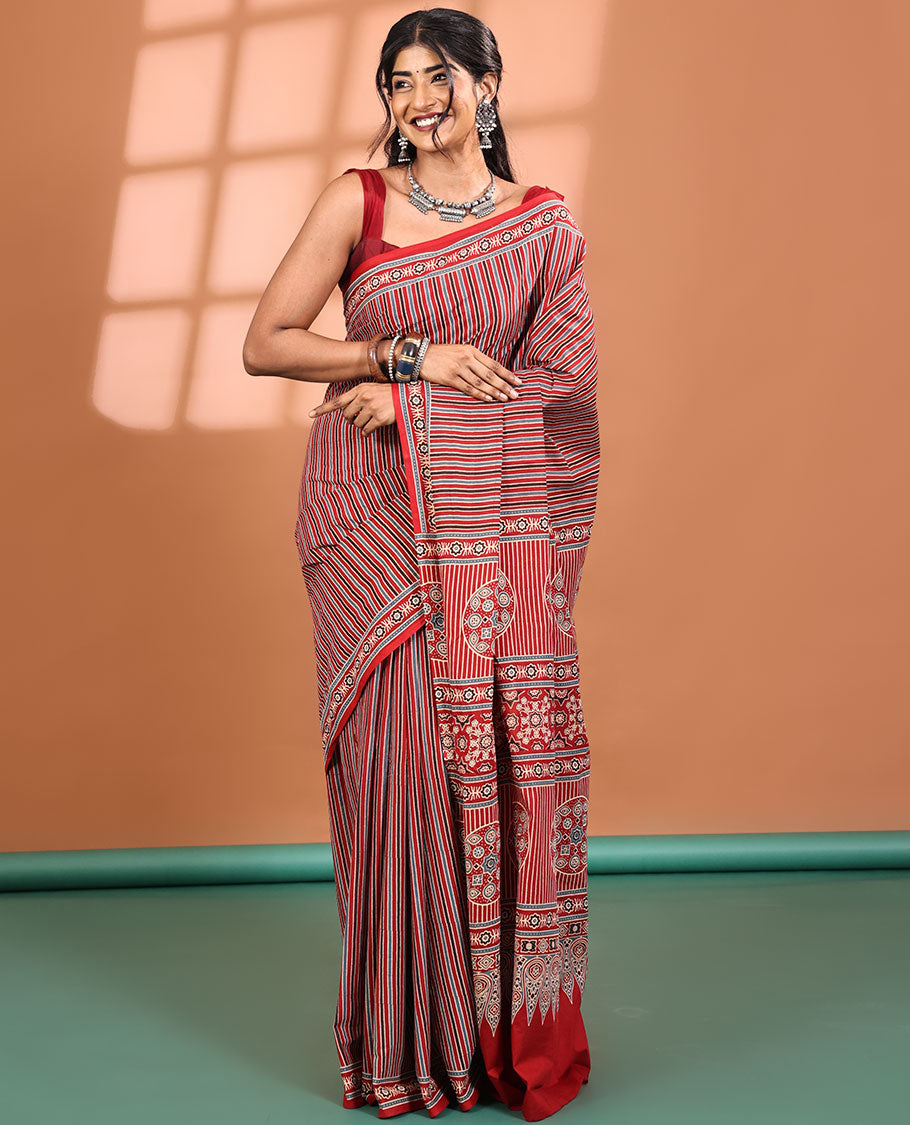 Red-base Saree, Subtly Sparkled with Vertical Stripes All Across Its Body, Highlighted by Floral Ajrakh-style Printed Border, Ajrakh Printed Pallu, and Paired with a Matching Blouse
