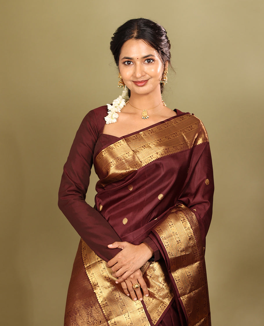 Brown Kanchipuram Silk Saree, Adorned with Zari Buttas, a Zari Border of Iruthalai Pakshi, Thilakam, Kathir, Mayil, Yaanai, and Mayil Kann Designs, Jaal Pallu, and a Matching Blouse