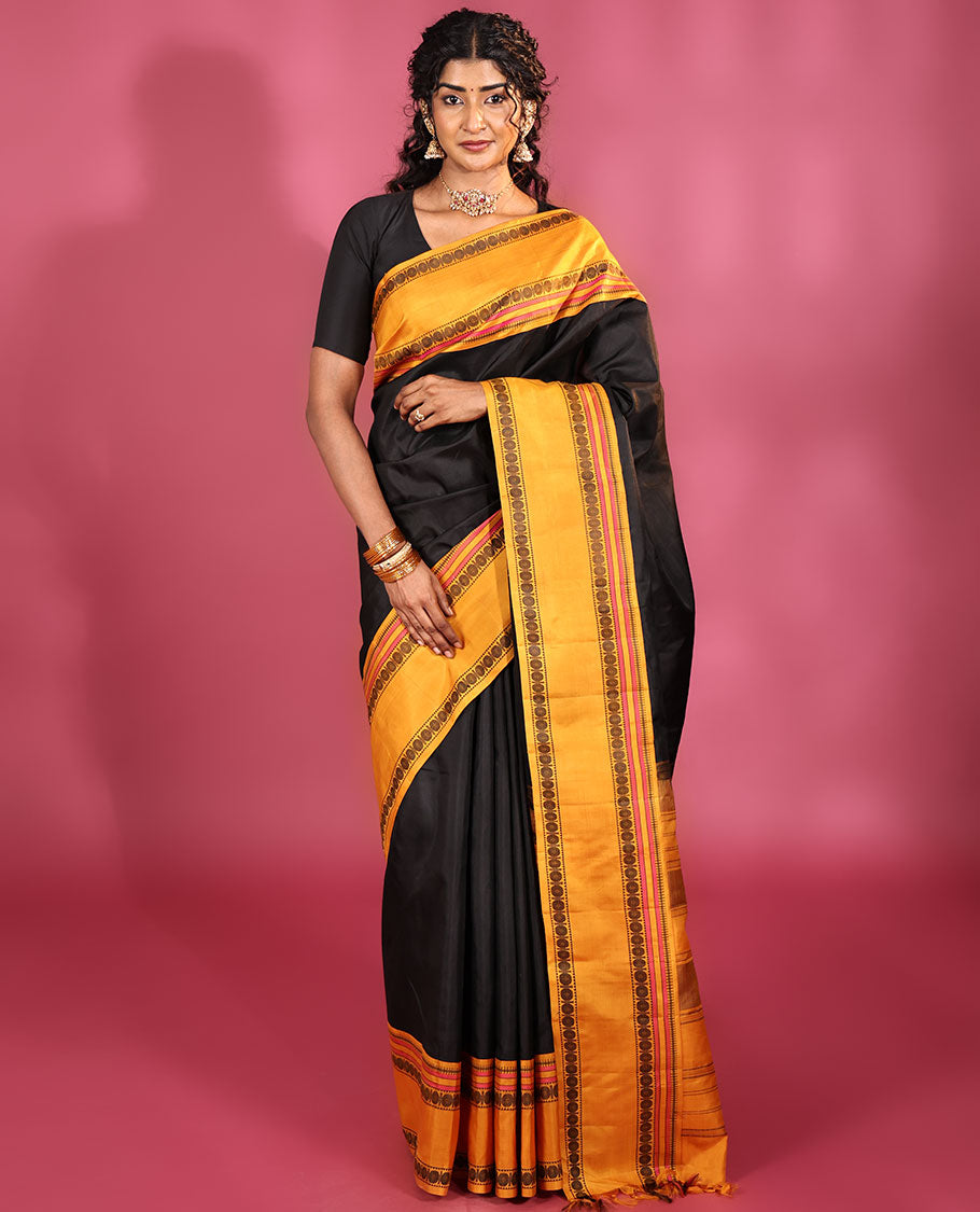 Black Plain Kanchipuram Silk Saree, Complemented by Captivating Contrast Rettai Pettu Border of Rekku, Muthu, and Rudraksham Designs, a Subtle Pallu of Thread Weave, and Paired with a Contrast Blouse