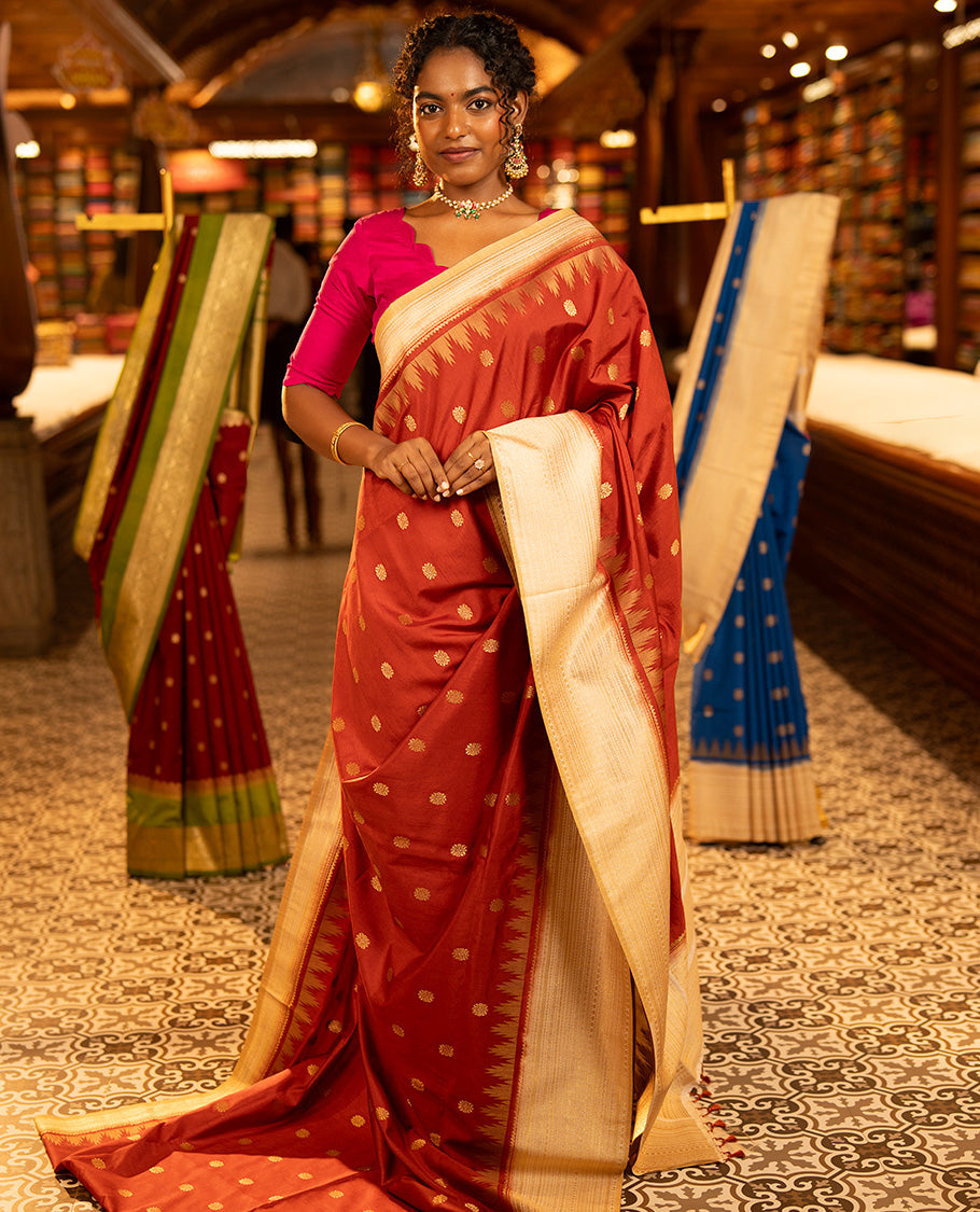 Rust Dupion Silk Saree, Decked Up with Zari Buttas All Over Its Body, Complemented by a Contrast Temple Traditional Zari Design Woven Border, Traditional Pallu of Temple Designs, and Paired with a Contrast Blouse